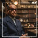 نجيب محفوظ يجلس في مقهى شعبي يعكس روح القاهرة القديمة